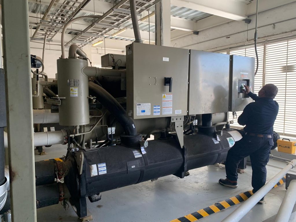 Técnico de PROCYCO revisando un chiller de tornillo enfriado por agua en cuarto de máquinas